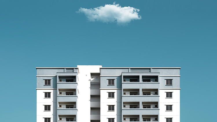 Top four floors of a condominium with a white cloud hovering above
