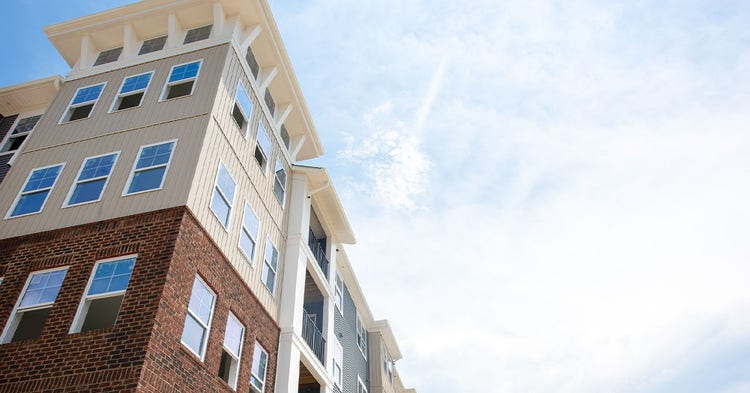 View of apartment building against a bright blue sky.