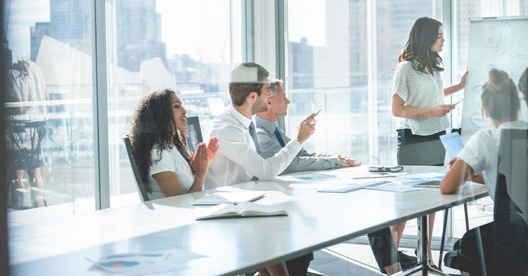 Business professionals meet in a glass conference room