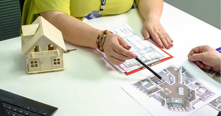 Two people in review of a residential floorplan.