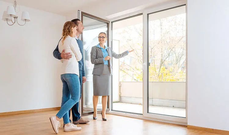 Female real estate professional shows a young couple a home