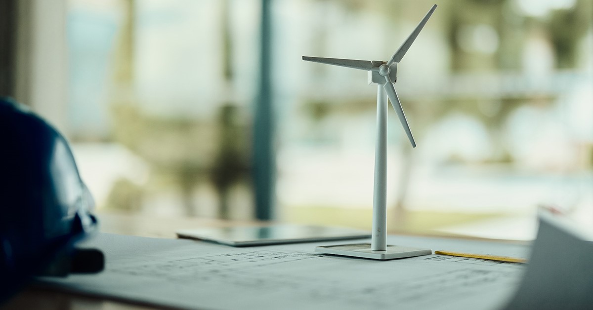 El modelo de turbina eólica se sienta en un escritorio en un entorno de oficina.