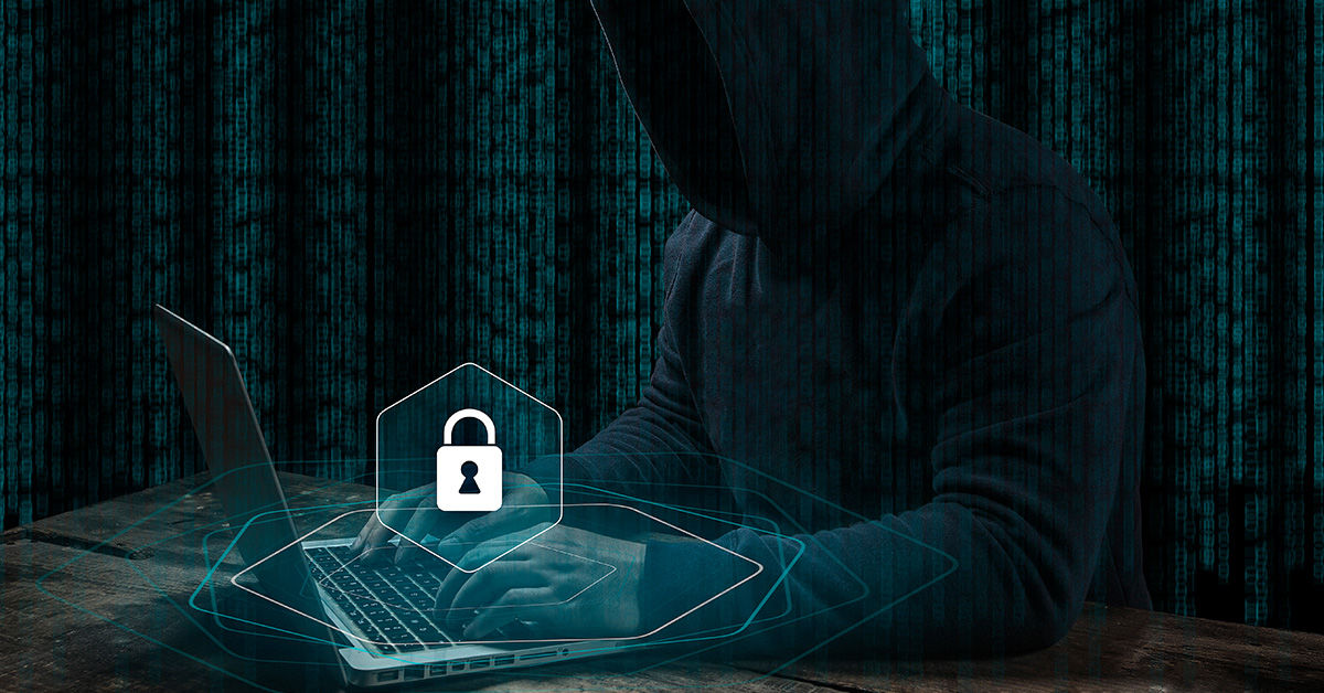 Figura con capucha en un ordenador portátil cometiendo un delito cibernético